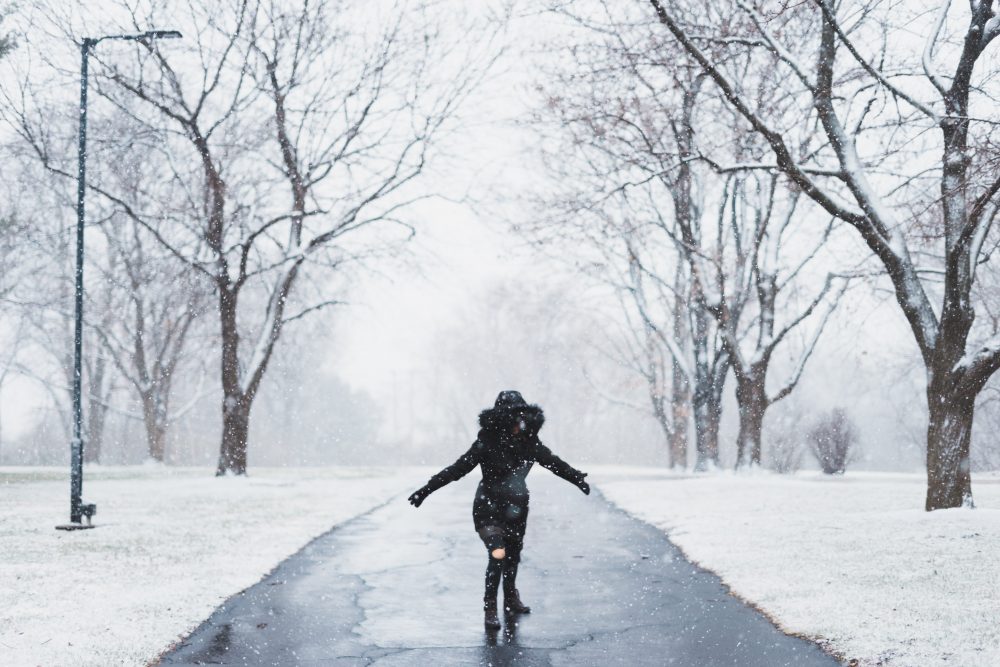 so what is the question this woman is asking in the snow with both hands in front of two trees