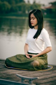 photo of asian woman enjoying the silence meditating