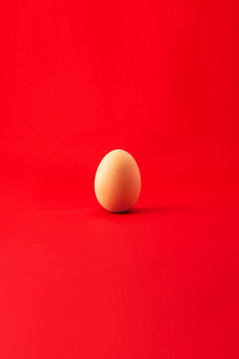 A lone egg in red background knowing how to allow and detach