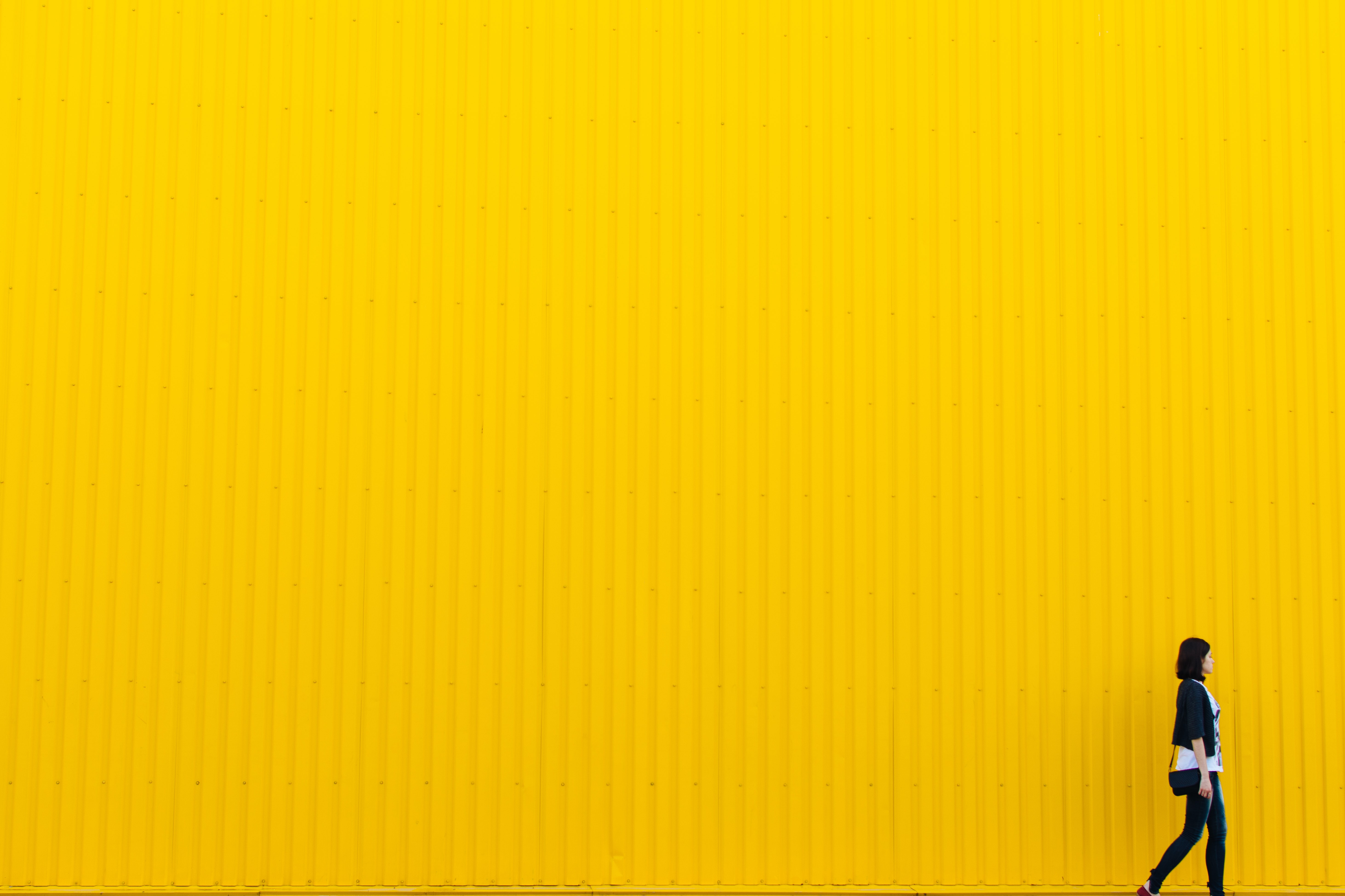 woman social distancing against a yellow background